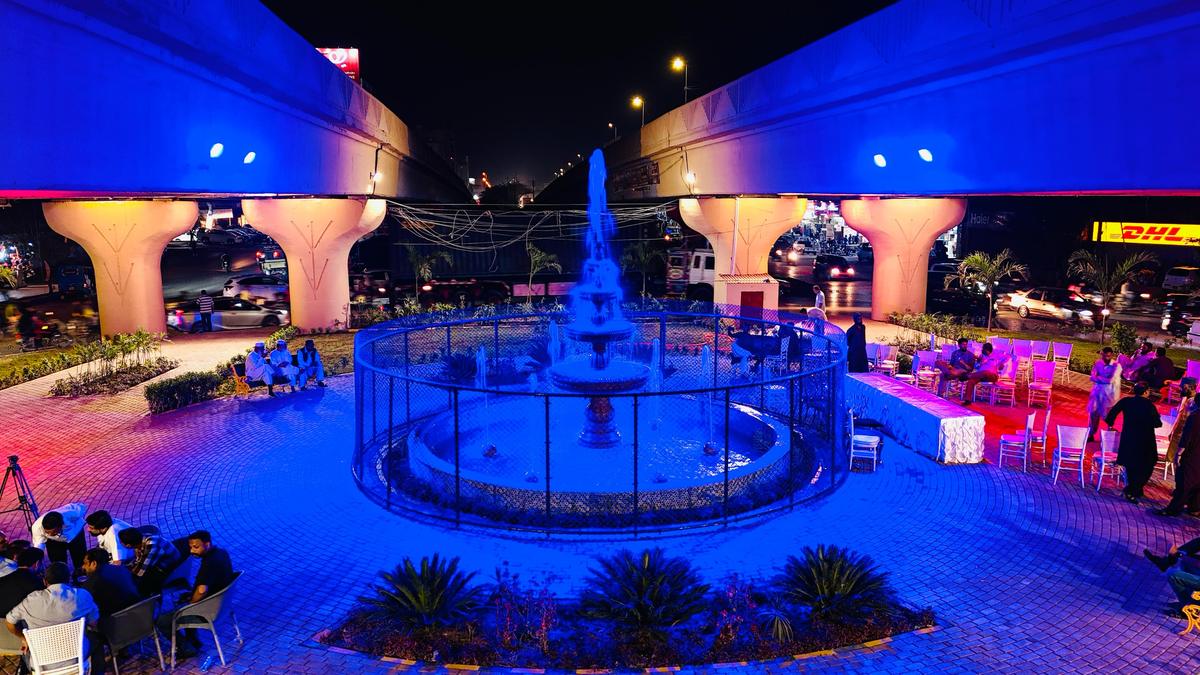 Blue-lit fountain park built under a flyover