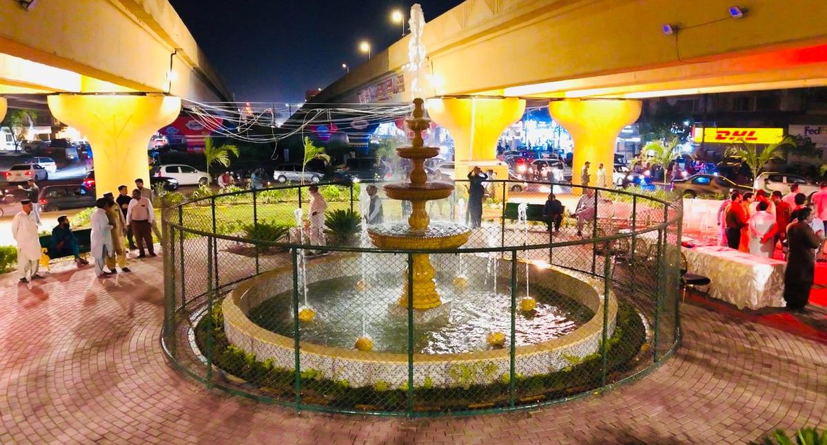 Fountain with a fenced garden under the flyover