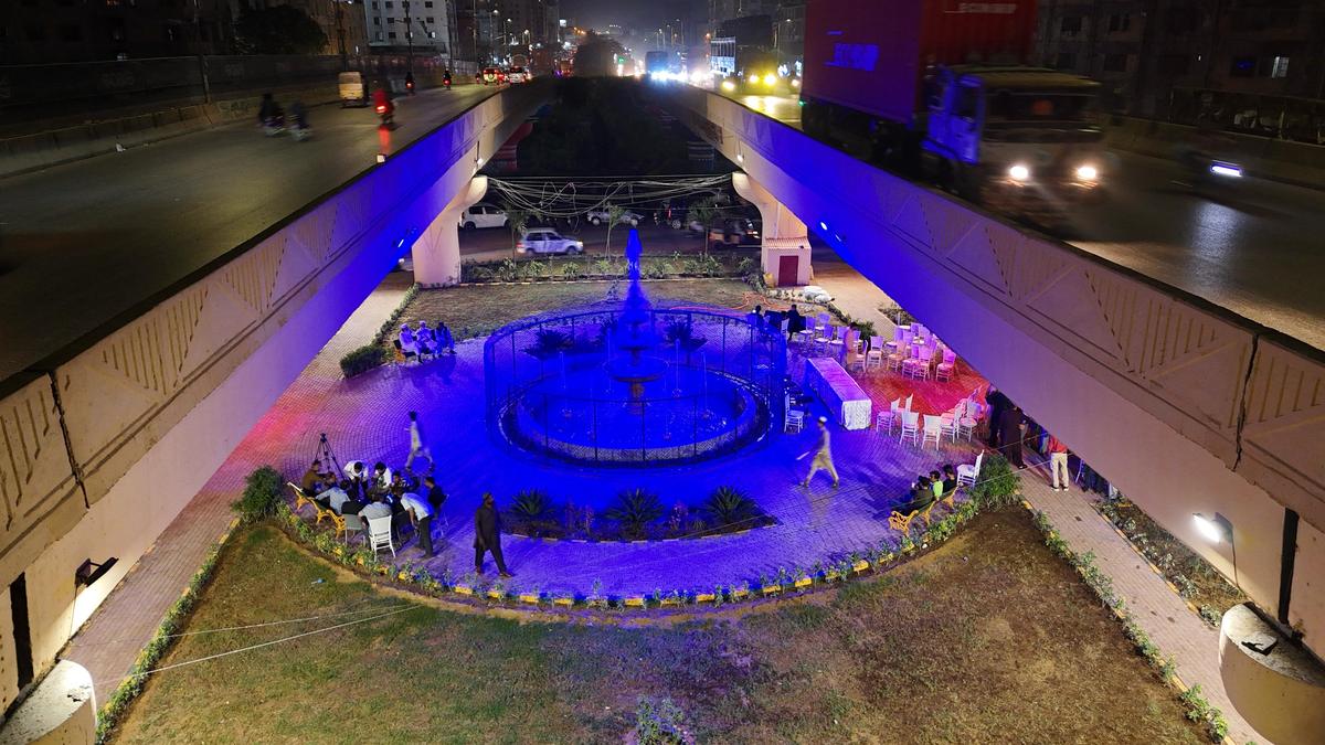 Underpass fountain lit in blue, viewed from the flyover